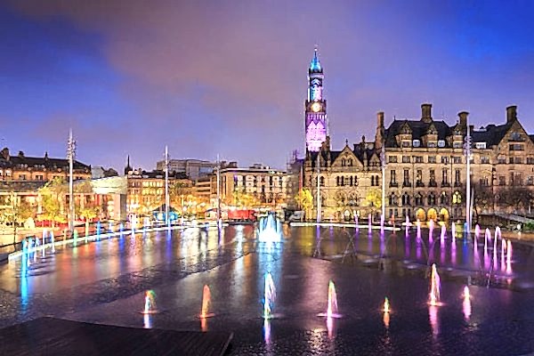 Dramatic night shot of Bradford Town Hall reflected in the mirror pool in the city park. Built in 2011 at a cost of over £24 million, it is hoped that the city park will attract extra tourists into the city centre.